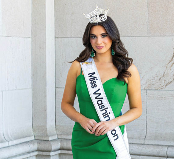 امرأة تقف بذراعين متقاطعتين بجانب نافذة