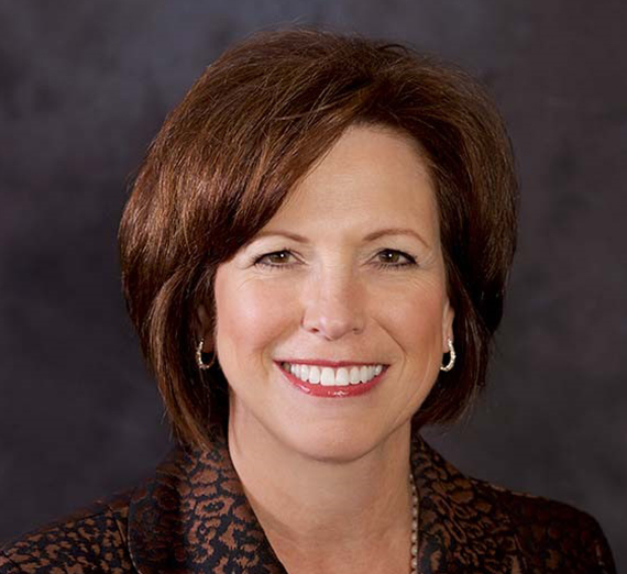 امرأة جالسة على كرسي بجانب منصة